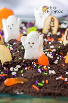 halloween treats in the shape of ghostes and tombstones on top of dirt with sprinkles