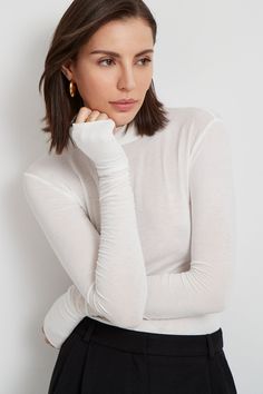 Meet our Sheer Addy Top, the ideal layering piece in our beloved sheer European jersey. She's a mock-neck top crafted from a translucent fabric, cut with a body-hugging fit with extra stretch. Her sleeves are finished with thumbholes for a signature Marcella touch of coziness with edge. Addy is also available in classic jersey.[SPLIT] Maritza, in light beige, is 5'9.5" (177 cm) tall, wearing size XS. Julia, in off white, is 5'10" (178 cm) tall, wearing size XS. Steph, in black, is 5'11" (180 cm) White Mock Neck Top, Haut Transparent, Translucent Fabric, High Turtleneck, Dating Girls, Autumn T Shirts, High Neck Top, Top Crafts, Womens Cami