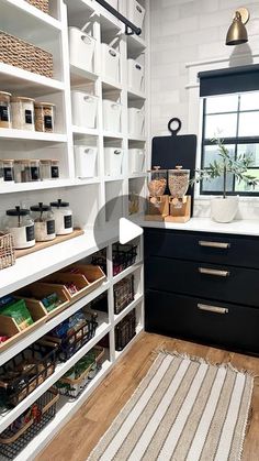 an organized pantry with white shelving and black drawers