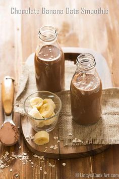 chocolate banana oats smoothie in glass jars on a cutting board with spoons