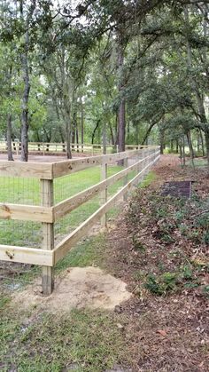 a fenced in area with trees and grass