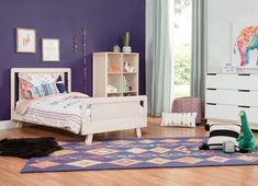 a child's bedroom with purple walls and white furniture