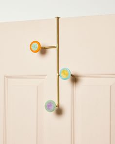 a door handle with three balls attached to it and hanging on the side of a door