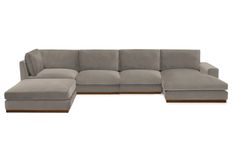 a large sectional couch sitting on top of a white floor next to a footstool