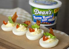 deviled eggs with bacon and lettuce on a cutting board