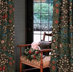 a chair sitting in front of a window with curtains