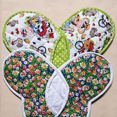 three bibs with different designs on them, one is green and the other is white