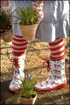 the legs and feet of a person wearing well - worn boots with flowers in them