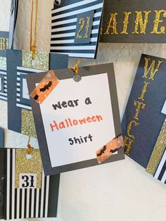 halloween decorations are hanging on the wall in front of a sign that says wear a halloween shirt