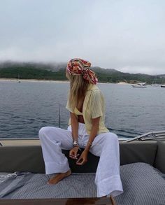 a woman sitting on the back of a boat