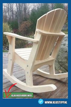 a wooden rocking chair sitting on top of a wooden deck next to a wooded area