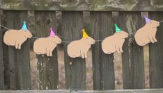 some paper elephants are hanging on a line with party hats and streamers attached to them