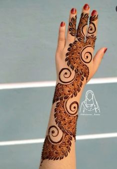 a woman's hand is decorated with hennap and swirls on it