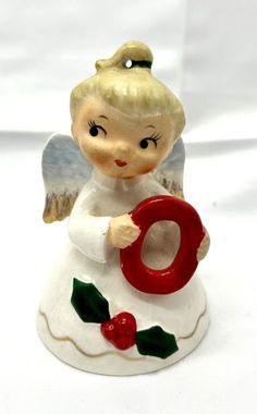 an angel figurine holding the letter o