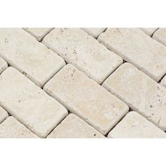 a close up view of white traver stone tiles