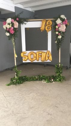 an entrance decorated with flowers and gold balloons