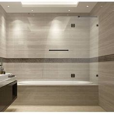 a bathroom with a tub, sink and mirror in it's center wall is shown