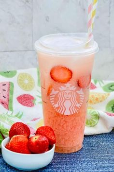 a starbucks drink with strawberries next to it