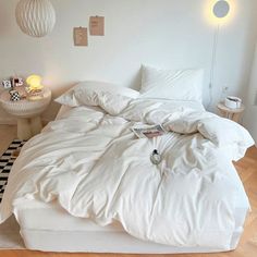 an unmade bed with white sheets and pillows on top of it in a bedroom