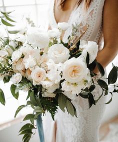 a woman holding a bouquet of white flowers in her right hand and the caption instagram