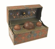 an old fashioned wooden box with three balls in it