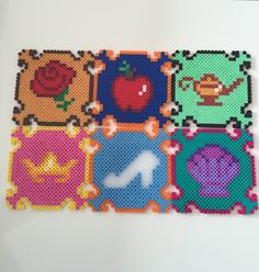 four pieces of perler bead art on a white surface, each with different designs