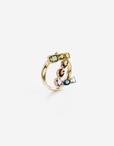 The line is completed by matching rings, characterized by a refined rounded yellow gold band with engraved logo and a pendant letter enriched by a veritable rainbow of natural gemstones such as topaz, garnet, amethyst, citrine, peridot and tourmaline. the shades of their colours, dominated by blue, green, purple, red, pink and yellow, evoke the warm atmospheres of Sicily. The multiple shapes of the crystals are also emphasized by the bezels, which alternate twisted thread processing and smooth surfaces. Technical specifications. Gold 18 Kt Gemstones. 1 square cushion light blue “Sky” topaz, 1 oval blue “London” topaz, 1 oval light purple amethyst, 1 oval orangish red hessonite garnet, 1 pear orange “Madera” quartz, 1 round light yellow citrine, 1 square cushion yellowish green peridot, 1 r Fine Jewelry Yellow Gold Multi-stone Ring, Yellow Gold Multi-stone Rings Fine Jewelry, Elegant Multicolor Rings With Bezel Setting, Luxury Yellow Gold Multi-stone Jewelry, Multicolor Polished Ring Jewelry, Multicolor Polished Finish Ring Jewelry, Multicolor Fine Jewelry With Polished Finish, Luxury 14k Gold Multicolor Jewelry, Multicolor Polished Fine Jewelry