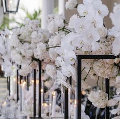 white flowers and candles are lined up along the wall in this elegant wedding ceremony setting