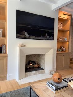 a living room filled with furniture and a flat screen tv mounted above a fire place