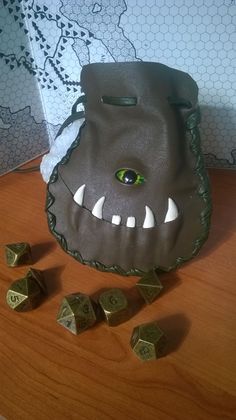 a bag that is sitting on top of a table with some dice in front of it