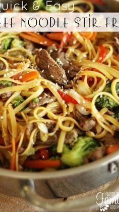 a skillet filled with beef noodles and broccoli, carrots and peppers