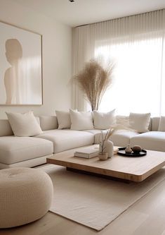 a living room with white furniture and large windows