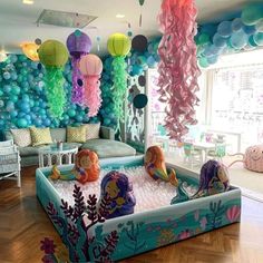 an inflatable pool with mermaid decorations and balloons