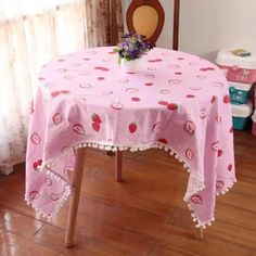 a pink table cloth with strawberrys on it