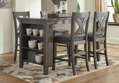 a dining room table and chairs in front of a fireplace