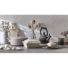 a table topped with pots and pans filled with flowers