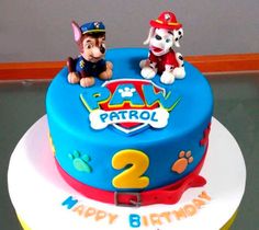 a birthday cake with two dogs on top and paw patrol written on the bottom layer