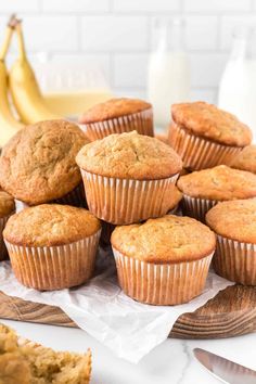 several muffins on a wooden tray next to some bananas