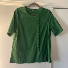 Short Sleeve Cotton/Poly Blouse, Size L. Green, Round Neck, Cute Asymmetrical Button Detail Down Front. Vents At Hem. Never Worn. Spring Workwear Tops With Side Buttons, Casual Tops With Side Buttons For Summer, Green Short Sleeve Blouse With Buttons, Green Blouse With Placket, Casual Short Sleeve Tops With Covered Buttons, Button Detail, Short Sleeve Blouse, Sleeve Cotton, Sleeve Blouse