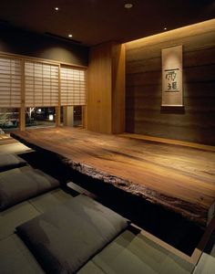 an empty room with wood flooring and large window shades on the windowsills