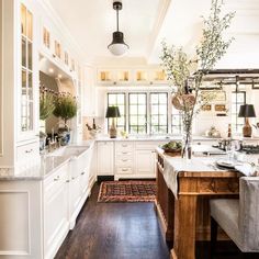 a large kitchen with white cabinets and wood floors