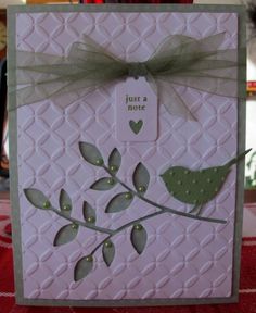 a close up of a greeting card with a bird on a tree branch and hearts