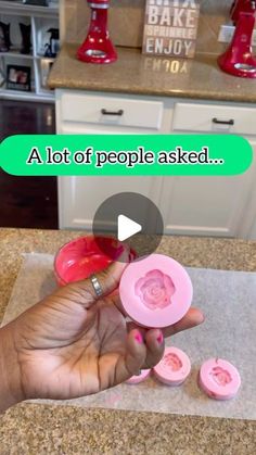 a person is holding some pink buttons in their hand and pointing to the button that says, a lot of people asked