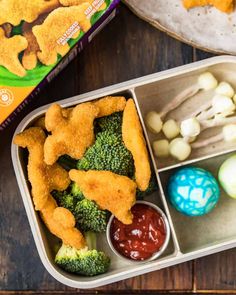 a bento box filled with chicken nuggies, broccoli and eggs