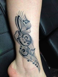 a tattoo with musical notes on it's foot and an ink pen in the shape of a treble