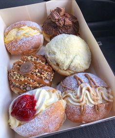 a box filled with different types of donuts