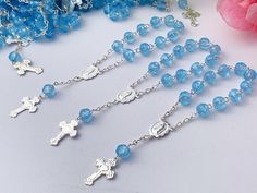 "150 Rosarios pequeñitos o decenario en color azul., hechos a Mano con la Imagen de la virgen de Guadalupe , bañados en Plata y hechos de acrilico con figurita de rosa. Mide cerca de 10cm (4.5 Pulgadas) de largo y Los crystalitos importados son de 6 mm .. 150 pcs BLUE color ACRYLIC ROSEBUDS ON THIS MINI ROSARIES, ALL HAND MADE AND SILVER PLATED WITH BABY BLUE COLOR ACRYLIC BEADS IN SHAPE OF A ROSE BUD THEY MEASURE ABOUT 4.5\" INCHES LONG AND 4\" AROUND. CONVO US WITH Any QUESTIONS. Thanks!" Handmade Silver Rosary For Baptism, Personalized Silver Rosary For Confirmation, Blue Spiritual Jewelry For First Communion, Blue Cross Rosary As Gift, Blue Cross Rosary For Gift, Blue Rosary With Round Beads For Gift, Communion Party Favors, Mini Rosaries, Baptism Ideas