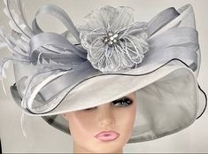 "The featured hat is a grey organza hat with an oversized bow made of grey crinoline loops.            A large organza loop is on one side of this large bow and a plume of long feathers  tha gradually curve. In the center of this design is a grey flower made from crinkle organza and has several beaded strands coming down from the flower. This hat is dramatic and gorgeous. It  would be perfect for the Kentucky Derby. Wear this hat and get that Audrey Hepburn vibe. Wear this hat and feel like a ru Audrey Hepburn Hat, Easter Hat, Flapper Hat, Easter Hats, Church Hat, Kentucky Derby Hat, Derby Hat, Grey Flowers, Church Hats