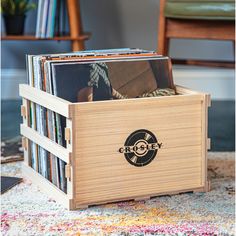 a wooden box filled with records on top of a rug