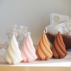 four different colored vases sitting on top of a table